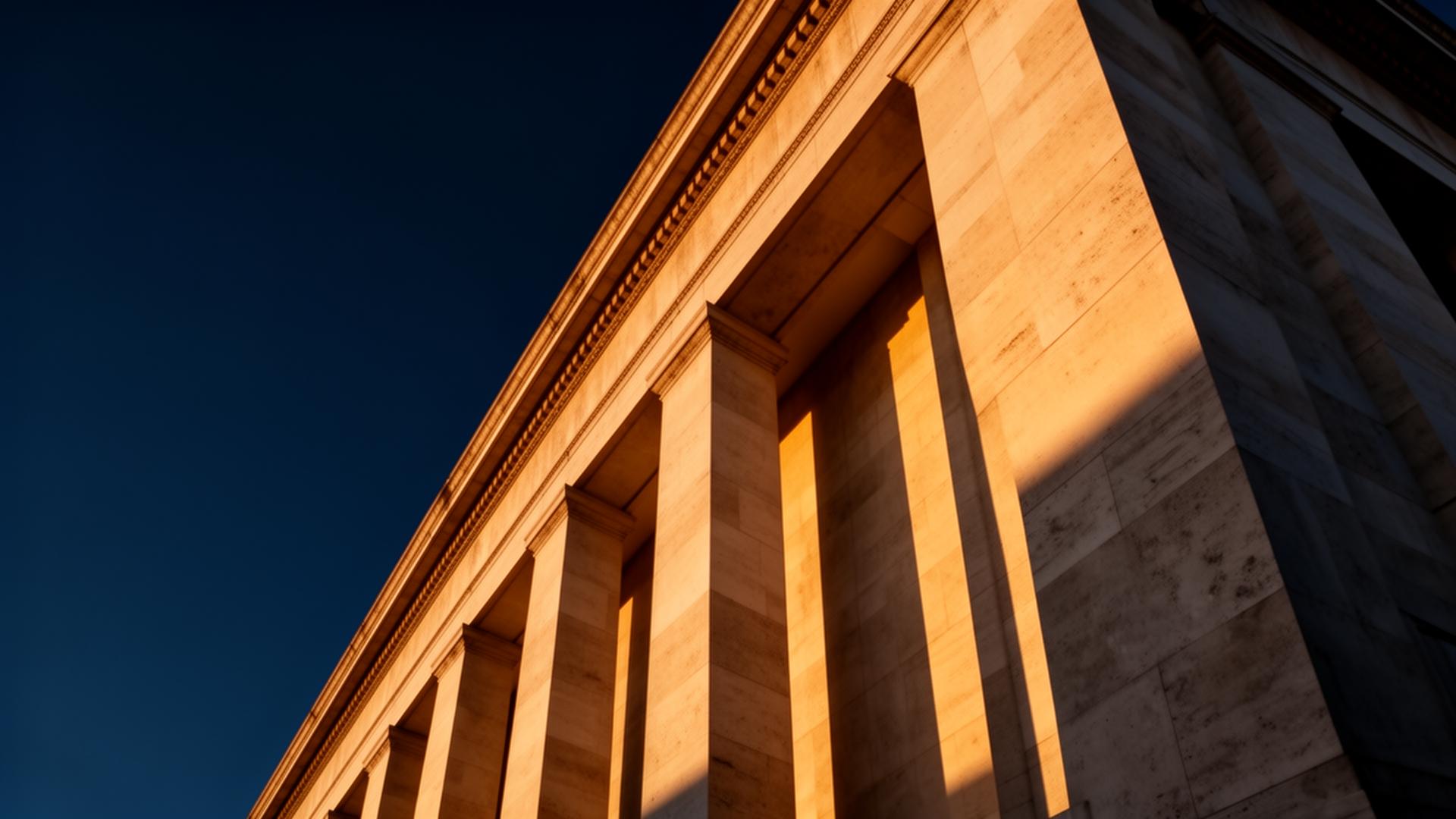 Limestone columns of a classical financial institution at golden hour